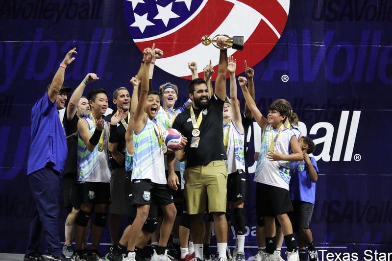 Boys volleyball team holding trophy