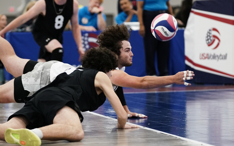 boy reaching for a ball digging