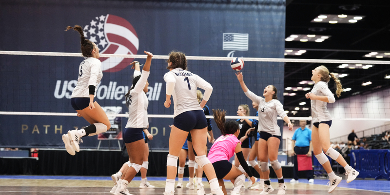 girl hitting over the net with a blocker